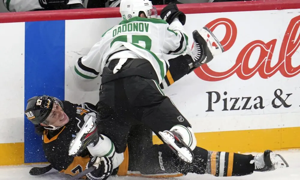 Dallas Stars' Evgenii Dadonov (63) checks Pittsburgh Penguins' Ryan Graves (27) into the boards during the first period of an NHL hockey game in Pittsburgh, Monday, Nov. 11, 2024. (AP Photo/Gene J. Puskar)