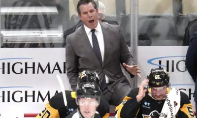 Pittsburgh Penguins head coach Mike Sullivan makes his point to linesman Matt MacPherson (83) during the first period of an NHL hockey game against the Dallas Stars in Pittsburgh, Monday, Nov. 11, 2024. (AP Photo/Gene J. Puskar)