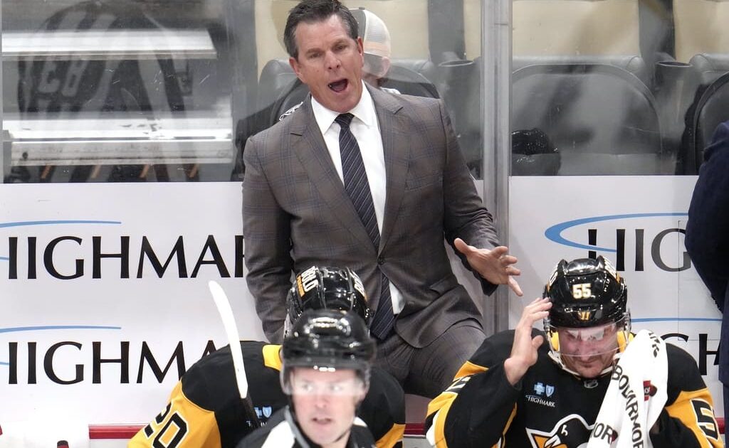 Pittsburgh Penguins head coach Mike Sullivan makes his point to linesman Matt MacPherson (83) during the first period of an NHL hockey game against the Dallas Stars in Pittsburgh, Monday, Nov. 11, 2024. (AP Photo/Gene J. Puskar)