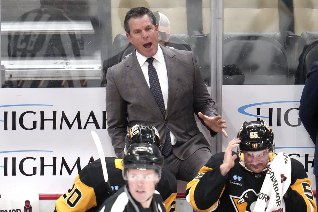 Pittsburgh Penguins head coach Mike Sullivan makes his point to linesman Matt MacPherson (83) during the first period of an NHL hockey game against the Dallas Stars in Pittsburgh, Monday, Nov. 11, 2024. (AP Photo/Gene J. Puskar)